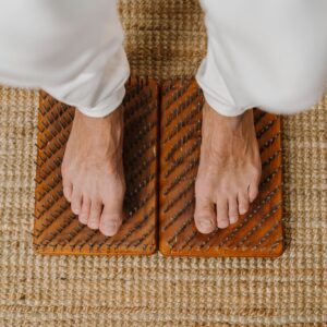 Close-up of feet on an acupressure board for holistic wellness practice.